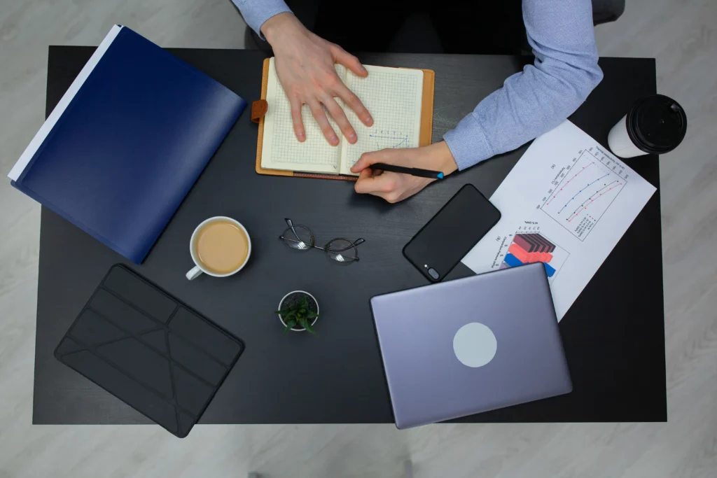 Bureau vu du dessus avec documents, café et ordinateur portable